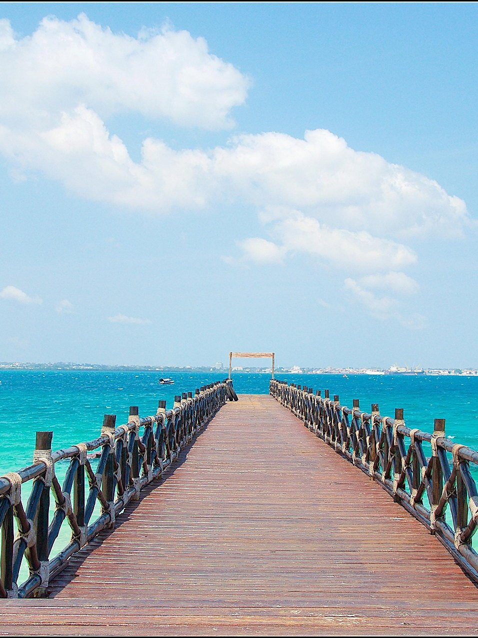 Wooden jetty reaching out into clear turquoise water on Zanzibar